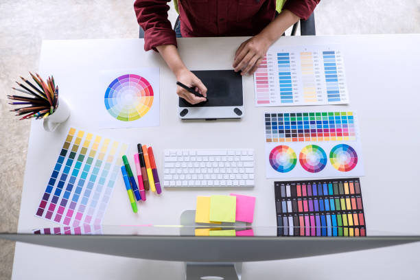 istock Image of female creative graphic designer working on color selection and drawing on graphics tablet at workplace, top view workspace 1090490908