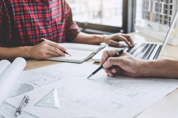 istock Hands of architect or engineer working on blueprint meeting for project working with partner on model building and engineering tools in working site, Construction and structure concept 1090490928