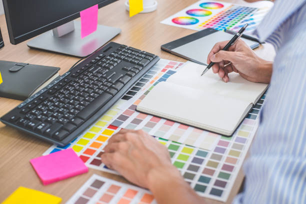 istock Image of male creative graphic designer working on color selection and drawing on graphics tablet at workplace with work tools and accessories in workspace 1090491714