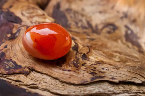 Red Carnelian against wooden background close up