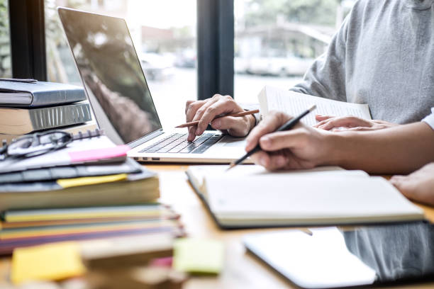 istock High school tutor or college student group sitting at desk in library studying and reading, doing homework and lesson practice preparing exam to entrance, education, teaching, learning concept 1090495368