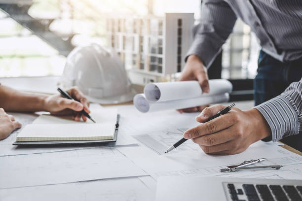 istock Construction and structure concept of Engineer or architect meeting for project working with partner and engineering tools on model building and blueprint in working site 1090495382