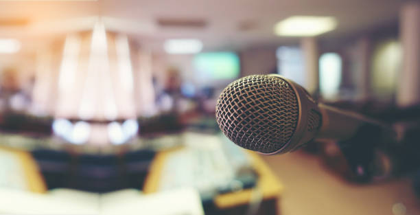 istock Vintage microphone over the Abstract blurred image of conference hall, study room or seminar room with attendee background, Small Business training concept, Public speaking 1090499340
