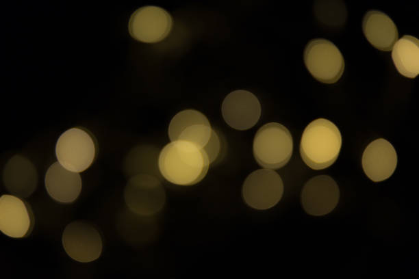 Shiny bokeh light particles on black background stock photo