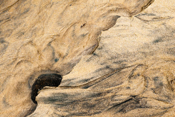 Water and sand form a graphic pattern on a beach in northern Brittany