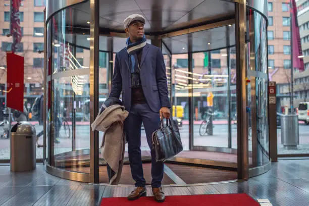 Photo of Handsome businessman entering the mall through a revolving door