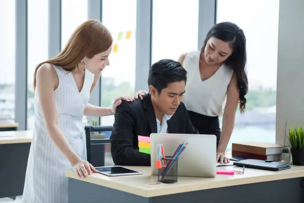 Businesswoman gestures and consolation Businessman in the office.  team work  girl employee patting man colleagues shoulder .consolation, sympathy, encouragement, in workplace