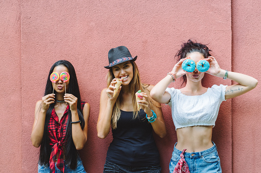 Young women having fun with sweet desserts