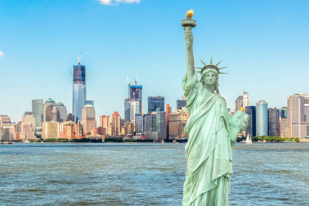 istock Lady Liberty standing in front of Manhattan skyline 1090518592