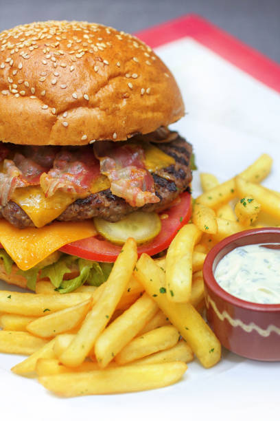istock Burger with ground beef and bacon, cheddar cheese and fries 1090526598