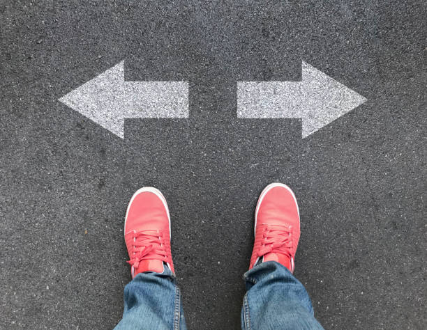 istock top view of feet and different direction arrows on asphalt road 1090529072