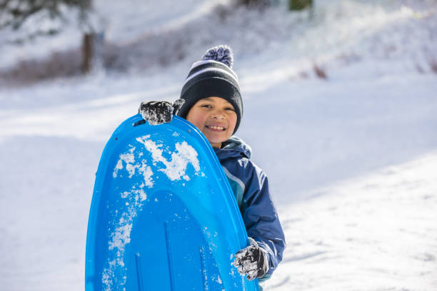 istock Young Boy Sledding Winter Wonderland 1090532730