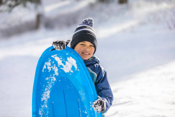 istock Young Boy Sledding Winter Wonderland 1090532944