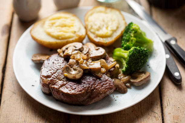 istock Steak with mushroom sauce, baked potatoes, broccoli 1090533324