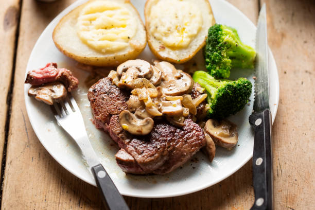 istock Steak with mushroom sauce, baked potatoes, broccoli 1090533328