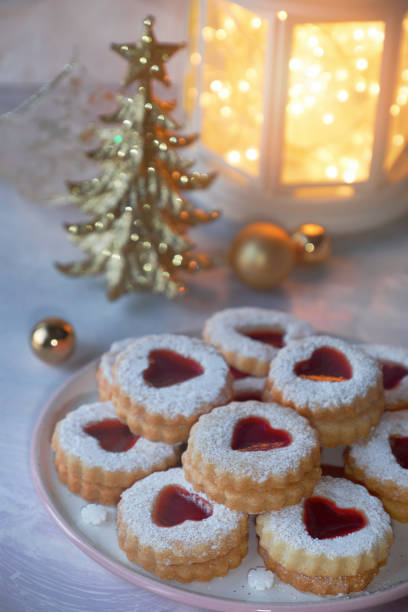 istock Traditional Christmas Linzer cookies filled with red jam on light table with Xmas decorations 1090535140