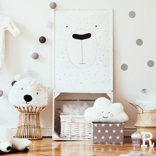 istock Scandinavian child room with mock up poster frame on the pattern wall, boxes, teddy bear and toys.Cute modern interior of playroom with white walls, wooden accessories and colorful toys. 1090539320