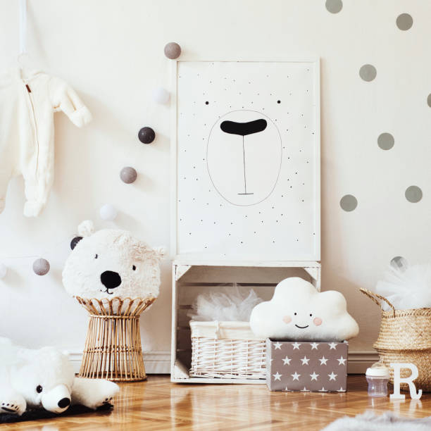 istock Scandinavian child room with mock up poster frame on the pattern wall, boxes, teddy bear and toys.Cute modern interior of playroom with white walls, wooden accessories and colorful toys. 1090539588