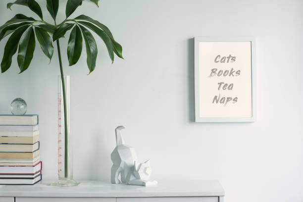 istock Stylish and minimalistic white interior with mock up frame , cacti figures, books and tropical leaf. White concept of cupboard shelf. 1090546766
