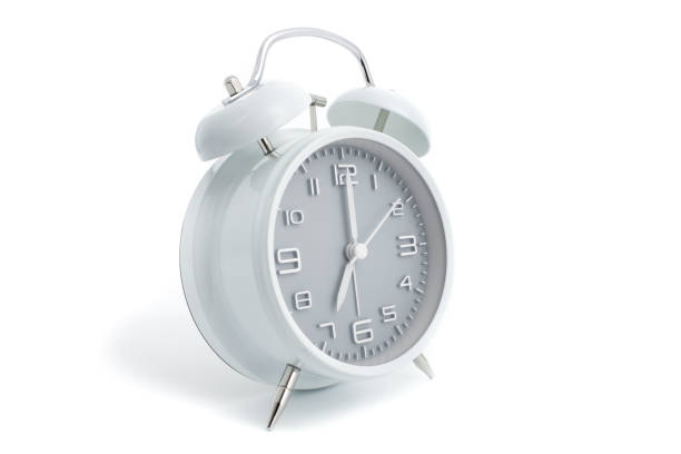 istock Twin bells analogue alarm clock with gray clock face shows seven o'clock, 7 AM PM; concept on white background 1090574892
