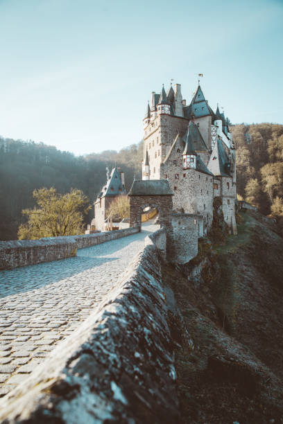 Beautiful view of famous Eltz Castle in scenic golden morning light at sunrise with blue sky on a sunny day in fall with retro vintage VSCO style filter effect, Wierschem, Rheinland-Pfalz, Germany