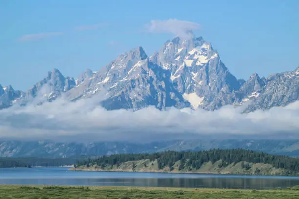 A view of the Grand Tetons in the morning before the clouds have cleared.