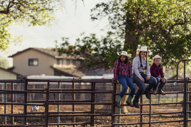 istock Three young cowgirls sitting on a fence. 1090581774