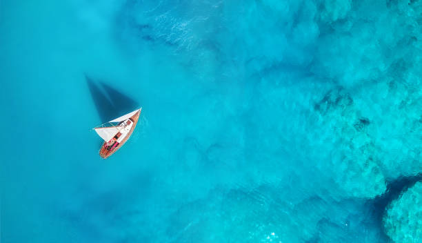 istock Yacht on the water surface from top view. Turquoise water background from top view. Summer seascape from air. Travel concept and idea 1090585080