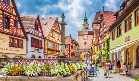 Beautiful postcard view of the famous historic town of Rothenburg ob der Tauber on a sunny day with blue sky and clouds in summer, Franconia, Bavaria, Germany