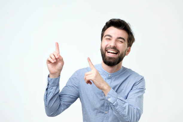 istock an smiling with happy face looking and pointing to the side with finger 1090589412