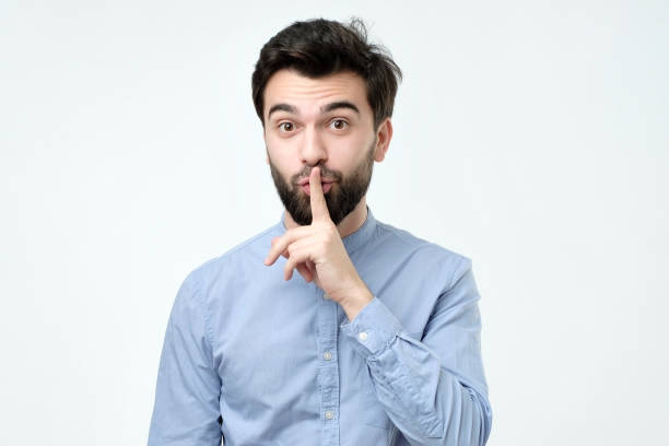 istock Hispanic man placing finger on lips as if to say, shhhhh, be quiet, silence. 1090589560