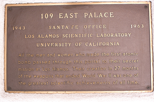 Santa Fe, NM: A historic bronze memorial plaque in downtown Santa Fe explaining the role played by Santa Fe and Los Alamos during the building of the Atomic Bomb during WWII. Close-up shot.