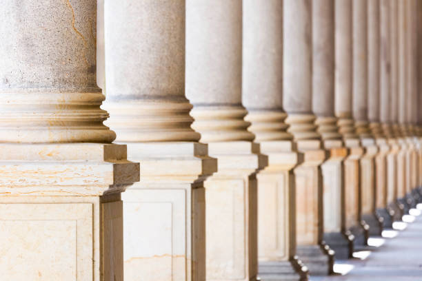 istock Colonnade, row of classical stone columns, background with copy spaced 1090594512