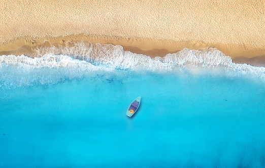 Seashore and boat from top view. Turquoise water background from top view. Summer seascape from air. Top view from drone. Travel concept and idea