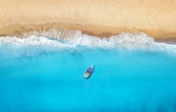 Photo of Seashore and boat from top view. Turquoise water background from top view. Summer seascape from air. Top view from drone. Travel concept and idea