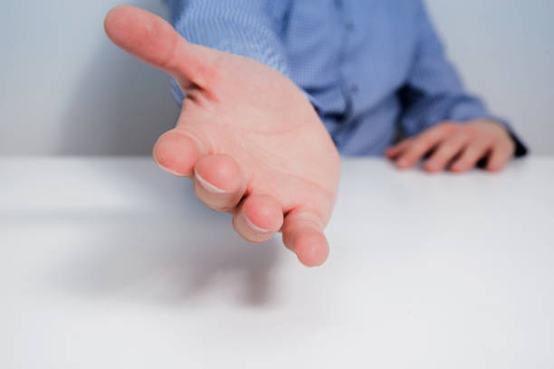 istock A man dressed in a blue shirt has his hands folded on the table. 1090598590