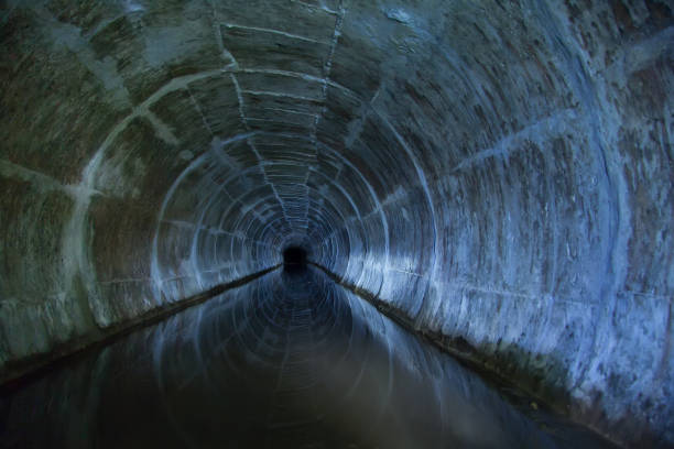 istock Flooded round sewer tunnel is reflecting in water 1090608432