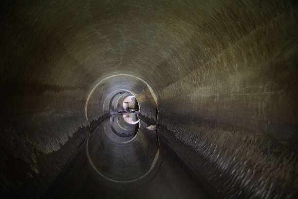 istock Flooded round sewer tunnel is reflecting in water 1090608510