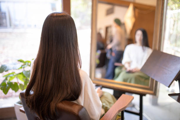 woman sitting in beauty salon - woman in mirror backview imagens e fotografias de stock