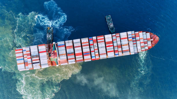 istock Aerial top view Tug boat drag container ship to sea port  for unloading container at crane bridge for import export, shipping or transportation. 1090645790