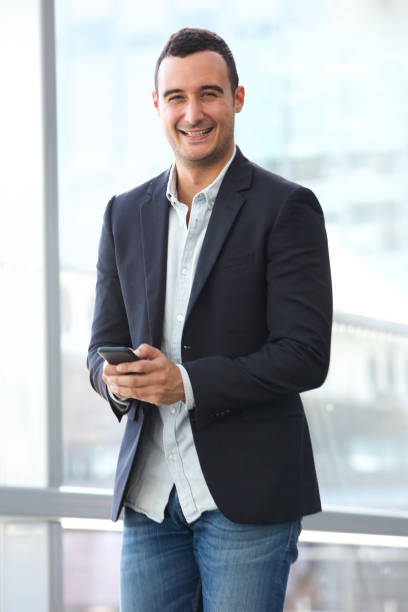 istock smiling businessman holding smart phone 1090648526