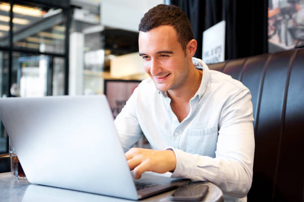 istock Close up smiling man sitting at cafe with laptop computer 1090648566