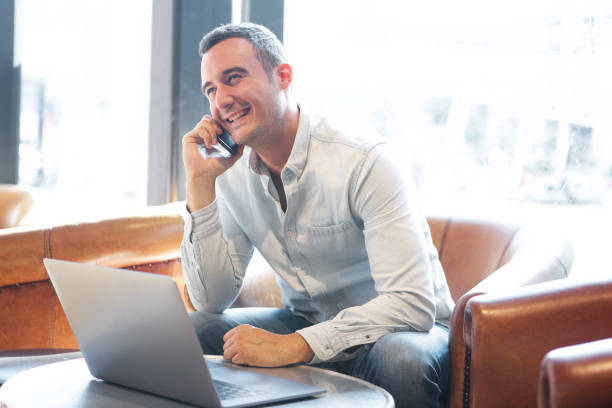 istock older guy with laptop talking on mobile phone at cafe 1090648578