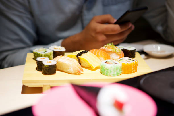istock male hands with mobile phone at sushi bar 1090648588