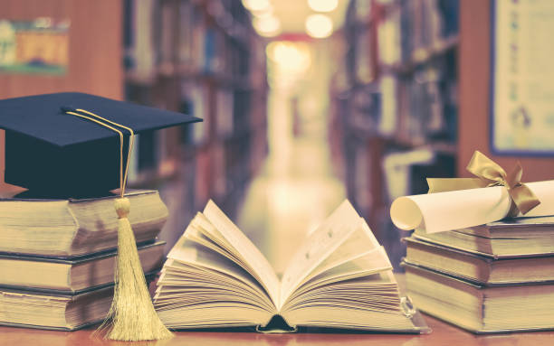 istock Education success with graduation hat, academic cap, mortarboard, and degree certificate on books and textbooks in class or library study room 1090650832