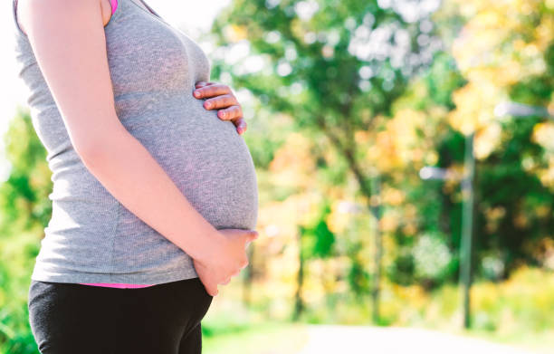 istock Pregnant woman standing outside 1090652078