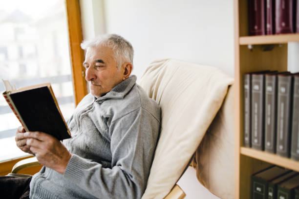 istock Senior Man Reading Book At Home 1090673984