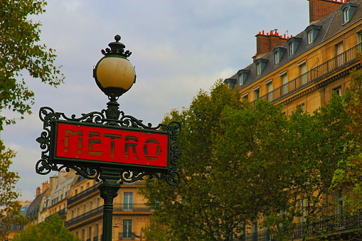 Typical french metro station sign and Parisian architecture – Paris, France