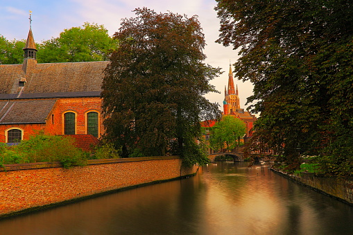 Medieval church architecture in Bruges canal and public park near Beguinage at sunrise - old town – Belgium