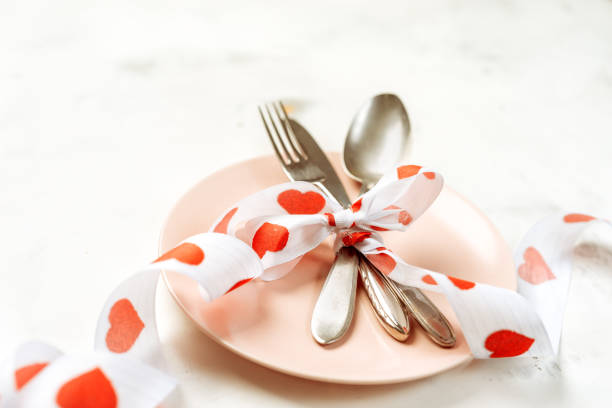 Festive table setting with cutlery and pink plate for Valentines Day